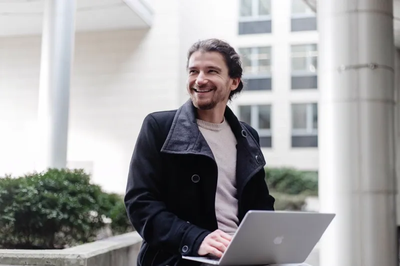 Gergő Stich working on his laptop outdoors